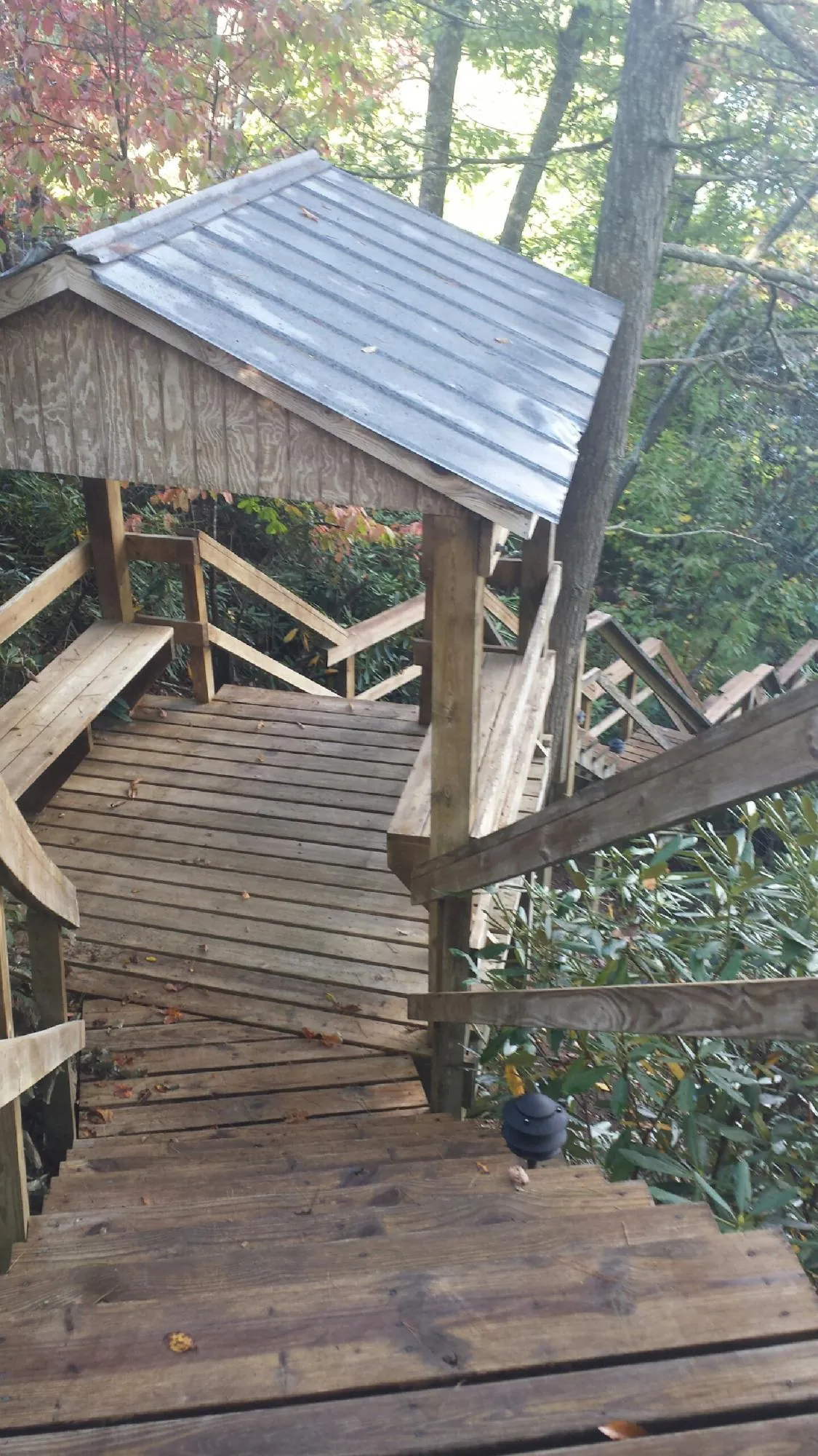 Metal roofed shelter over wooden steps on a wooded walkway — Skylight Repair & Installation work by our crew in Dwight