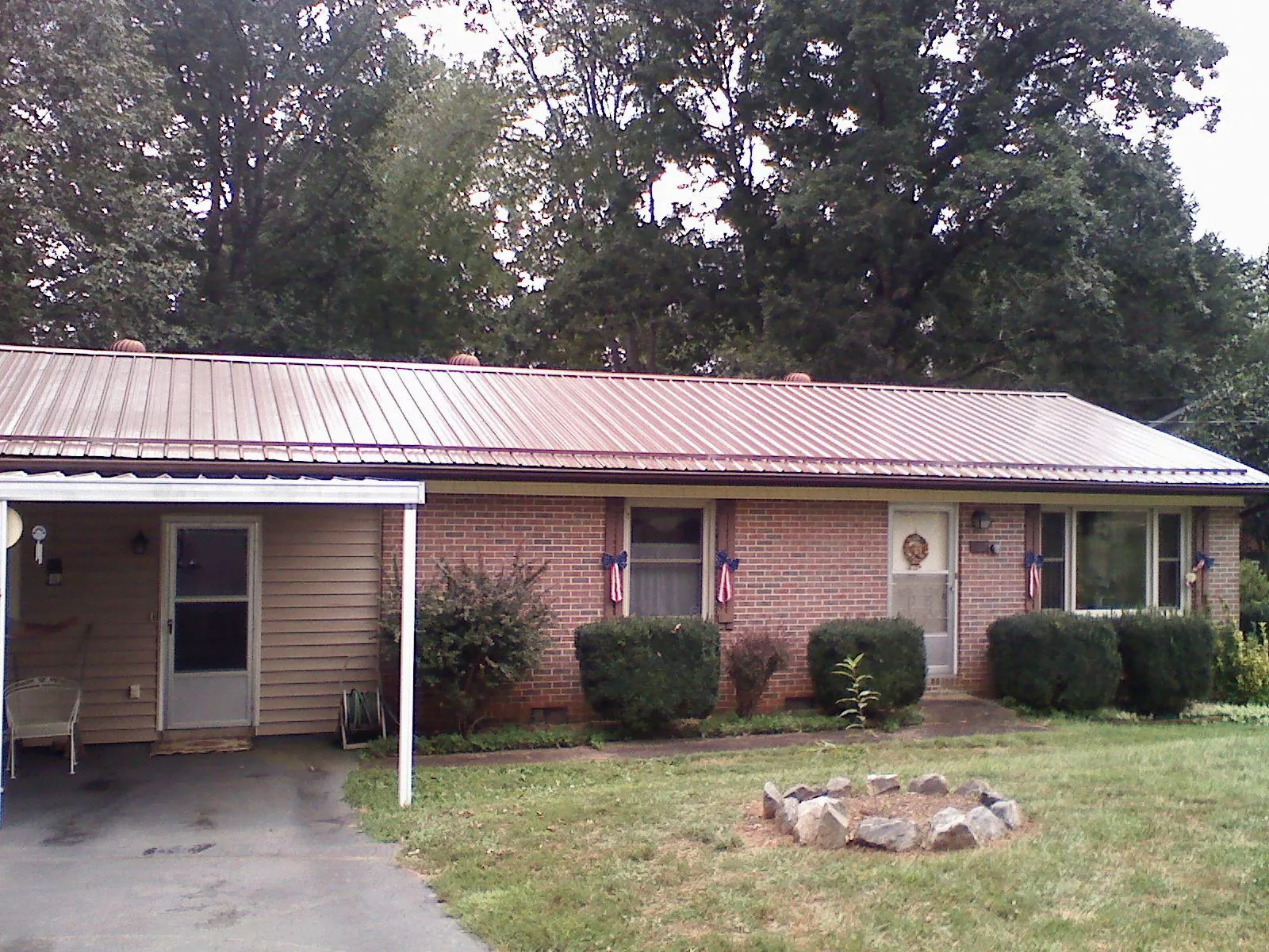 Bronze metal roof and carport on a brick ranch home — Roof Repair work by our crew in Dwight